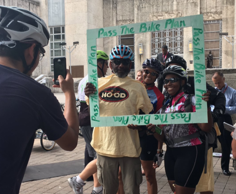 Supporters set up a selfie frame that says "Pass the Bike Plan"